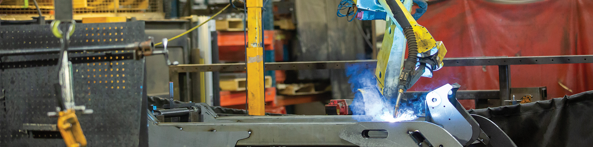 A welding robot welding a piece of metal at a Steffes manufacturing plant